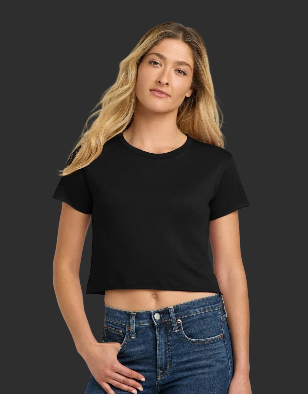 Woman wearing a black crop top and blue jeans on a white background