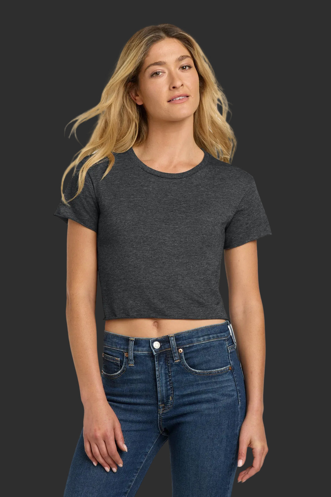 Woman wearing a dark gray t-shirt and blue jeans on a white background