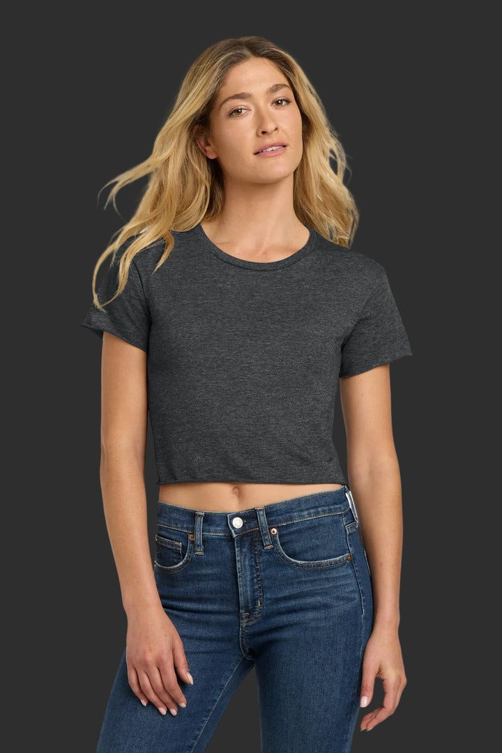 Woman wearing a dark gray t-shirt and blue jeans on a white background